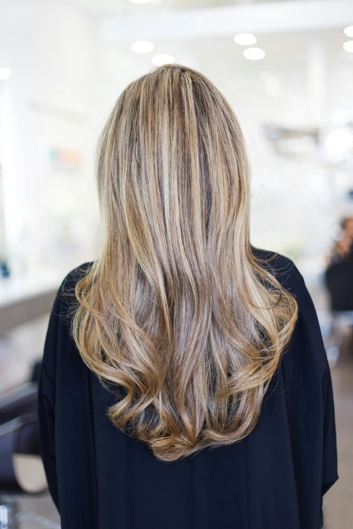 Capelli lunghi con mèches luminose e piega morbida